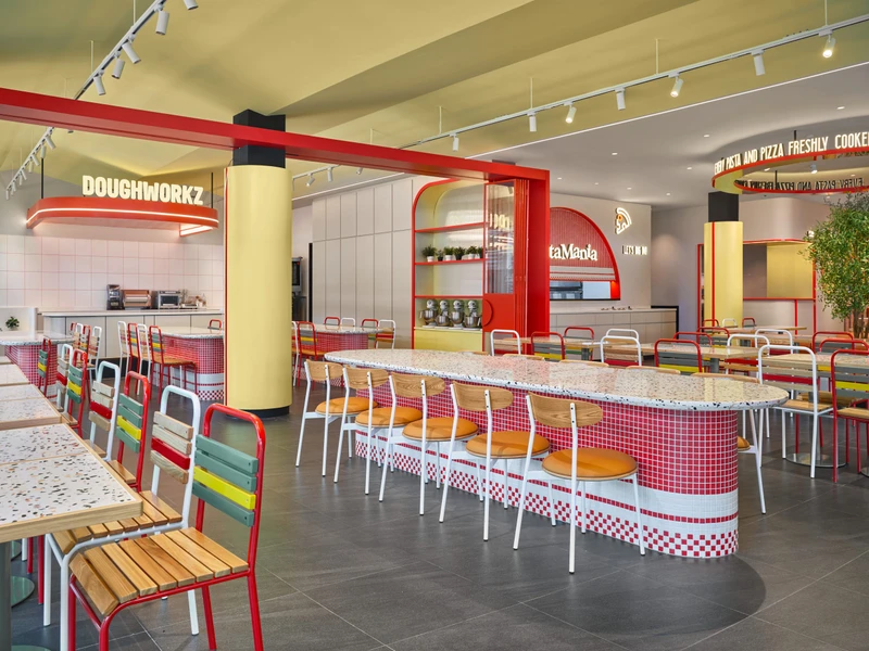 Doughworkz workshop zone with oval mosaic tables and arched display cabinet at PastaMania Sengkang