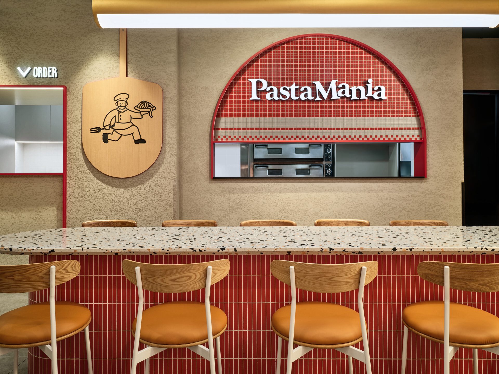 Arched pizza oven counter with mosaic tiles and brass pendant light at PastaMania Tampines