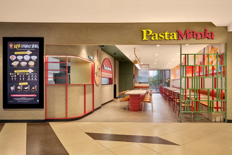 Curved facade with red display shelving and communal terrazzo counter at PastaMania Tampines