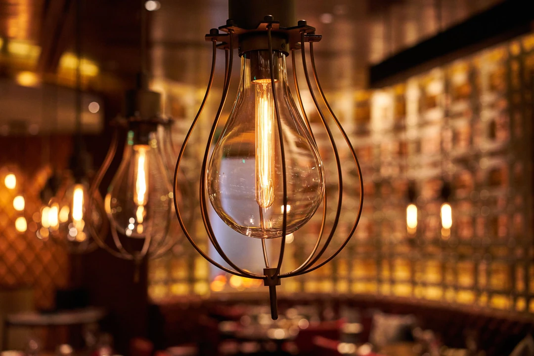 Teardrop cage pendant light detail with warm amber bokeh