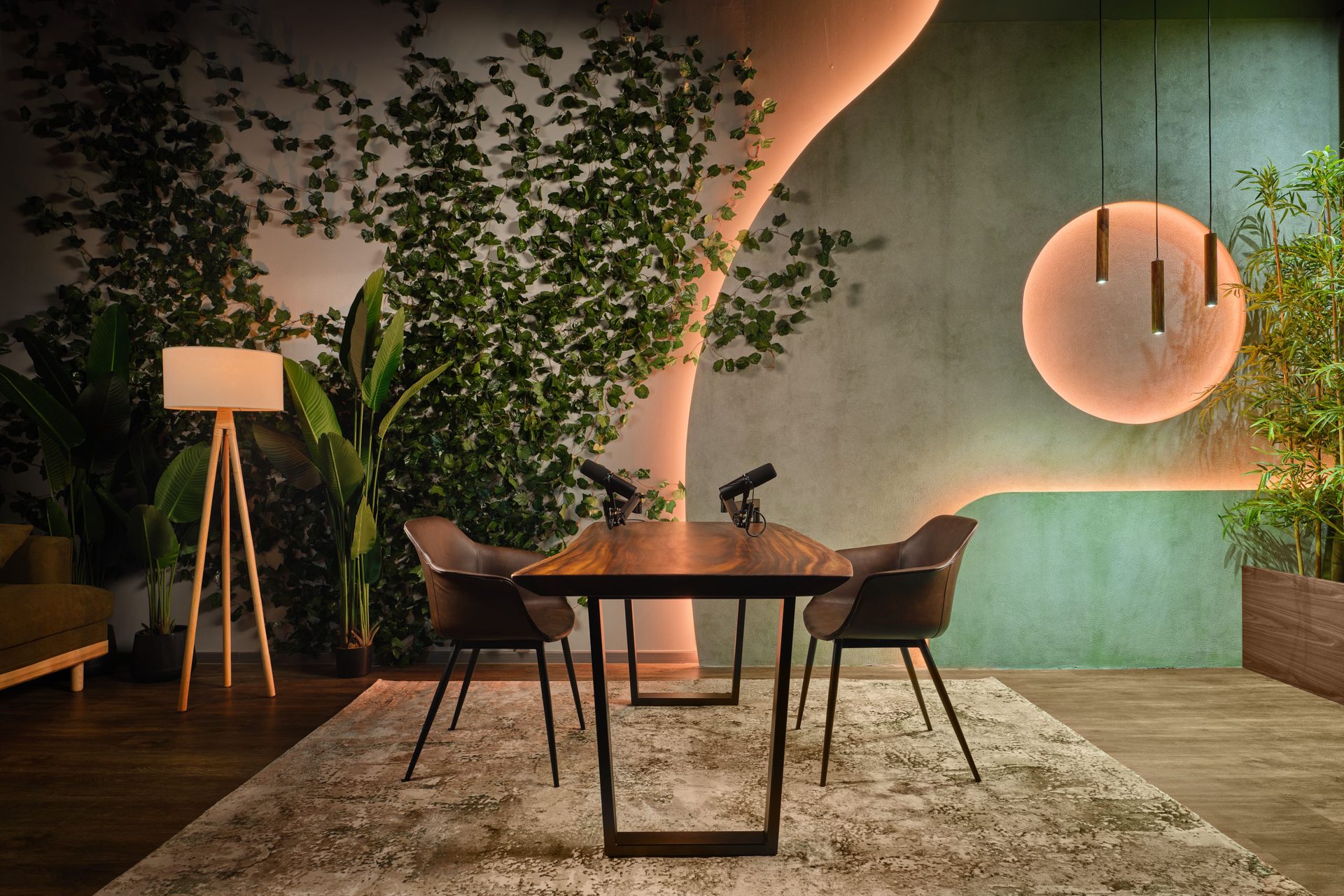 Biophilic podcast studio with living wall, live-edge table and leather chairs