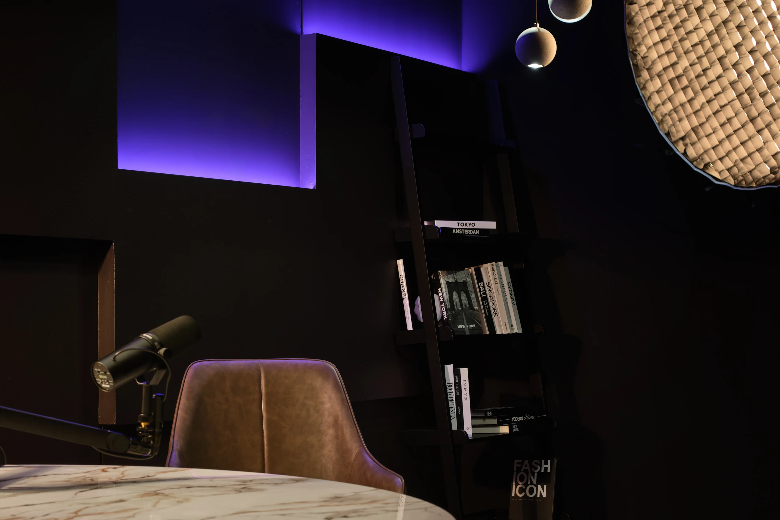 Minimal dark studio with marble table, halo ring light and microphones