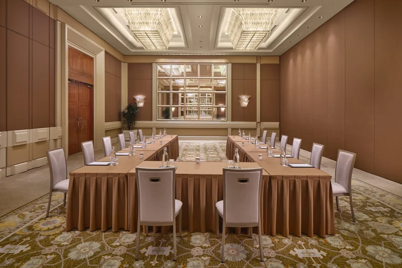 Conrad Singapore Marina Bay Grand Ballroom in East West U-shape setup with crystal ceiling lights, stage screens and patterned carpet