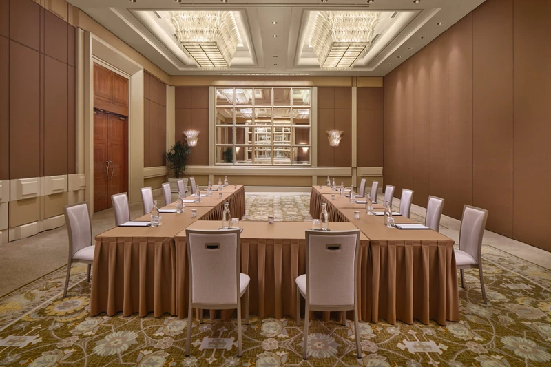 Conrad Singapore Marina Bay Grand Ballroom in East West U-shape setup with crystal ceiling lights, stage screens and patterned carpet