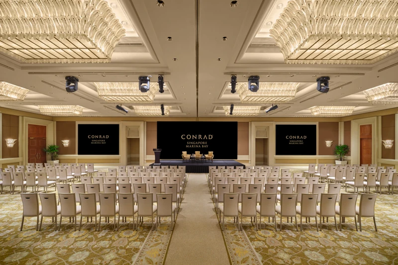 Conrad Singapore Marina Bay Grand Ballroom in North South theatre setup with crystal ceiling lights, stage screens and patterned carpet