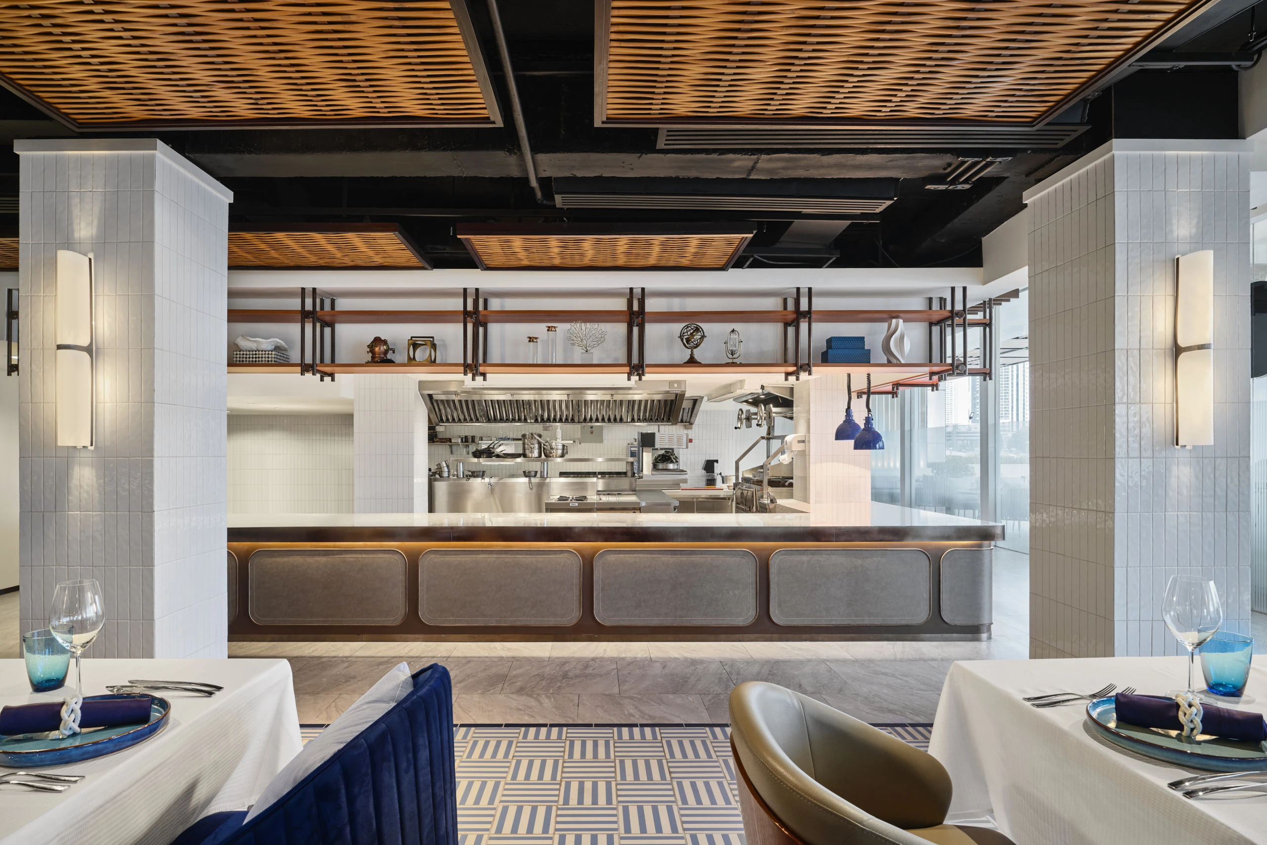 Open kitchen pass with Art Deco sconces and rattan ceiling panels — Siam Yacht Club Bangkok restaurant photography
