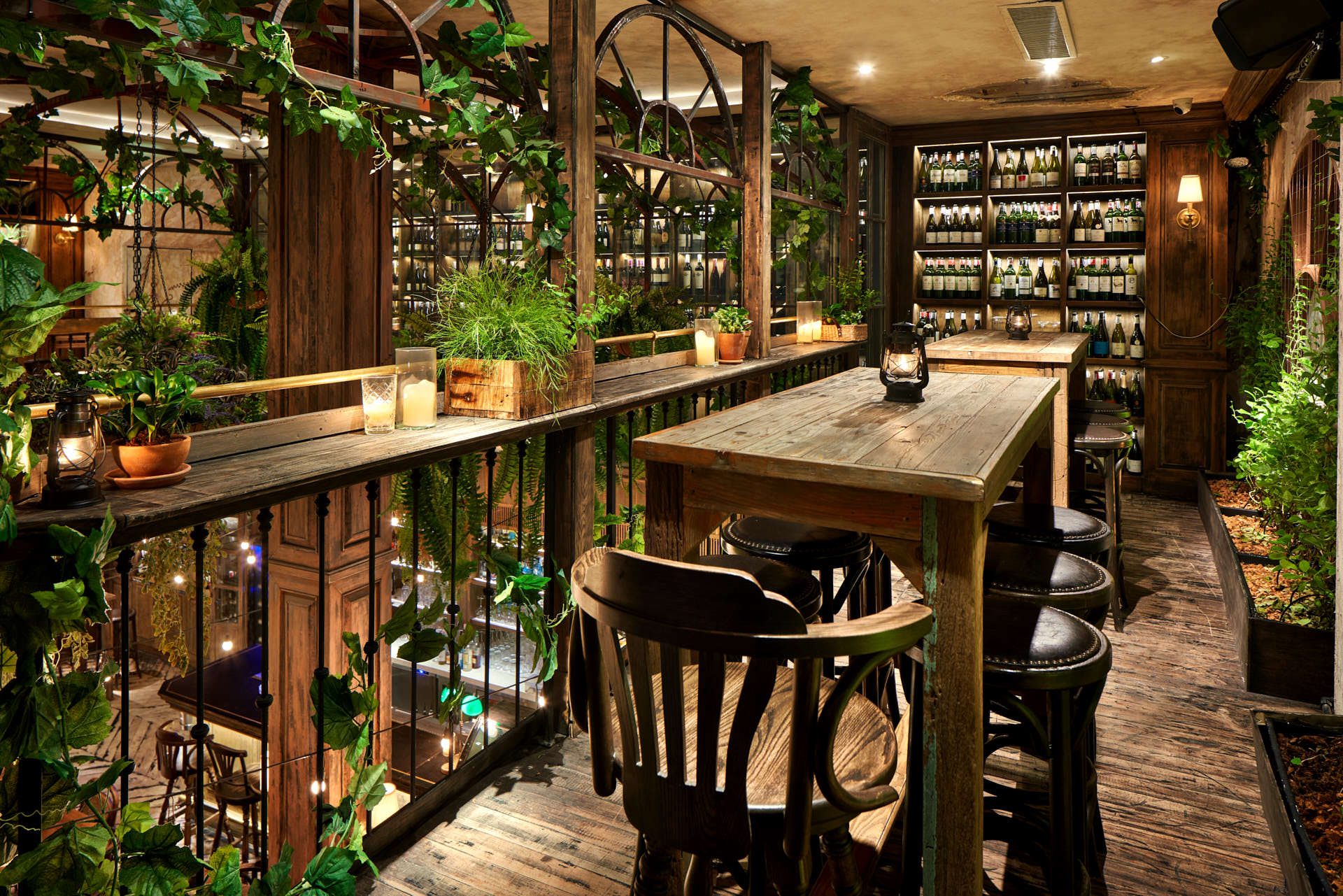 Mezzanine wine bar with reclaimed wood, bentwood stools and greenhouse arches
