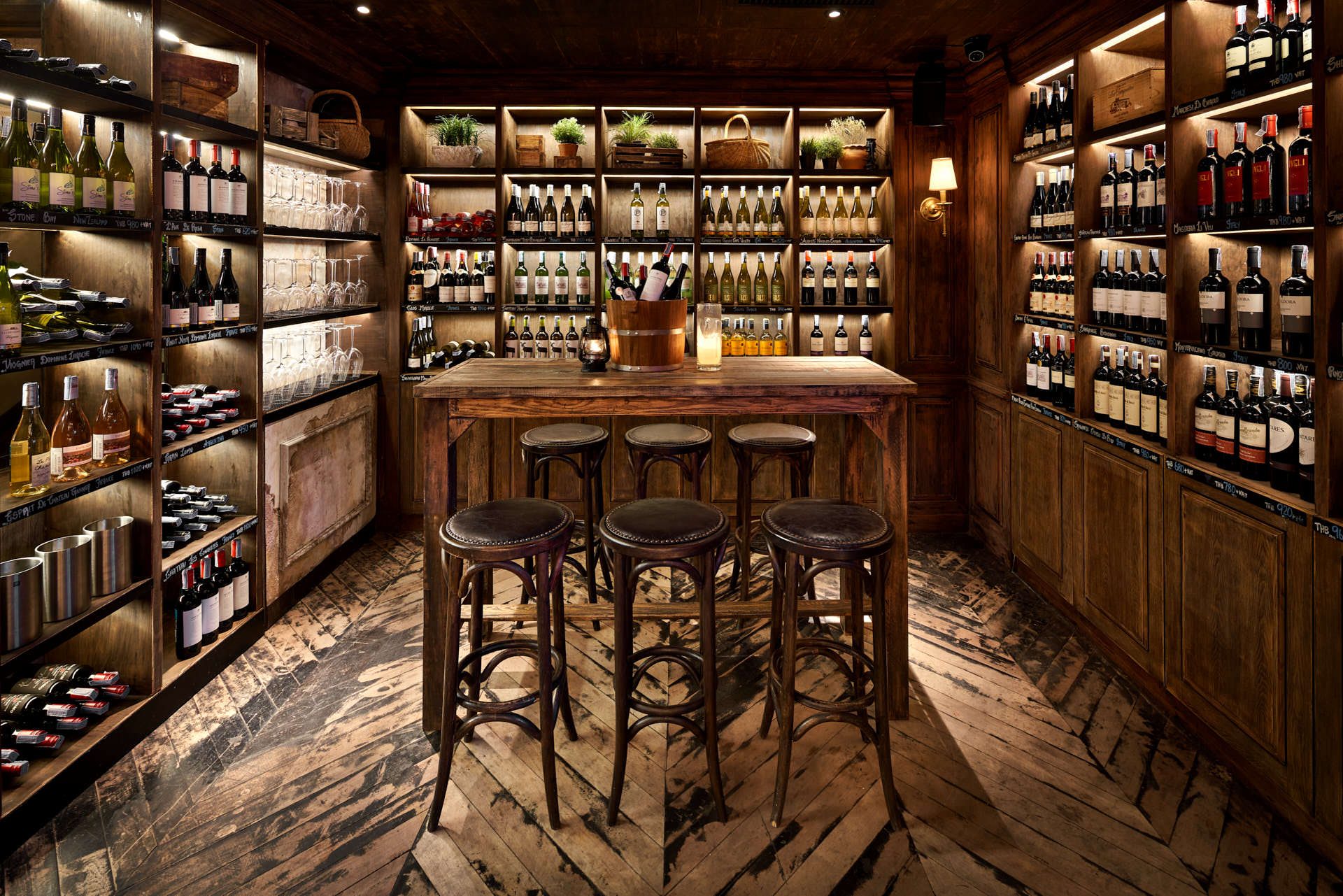Wine cellar with floor-to-ceiling shelving, farmhouse table and chalk labels