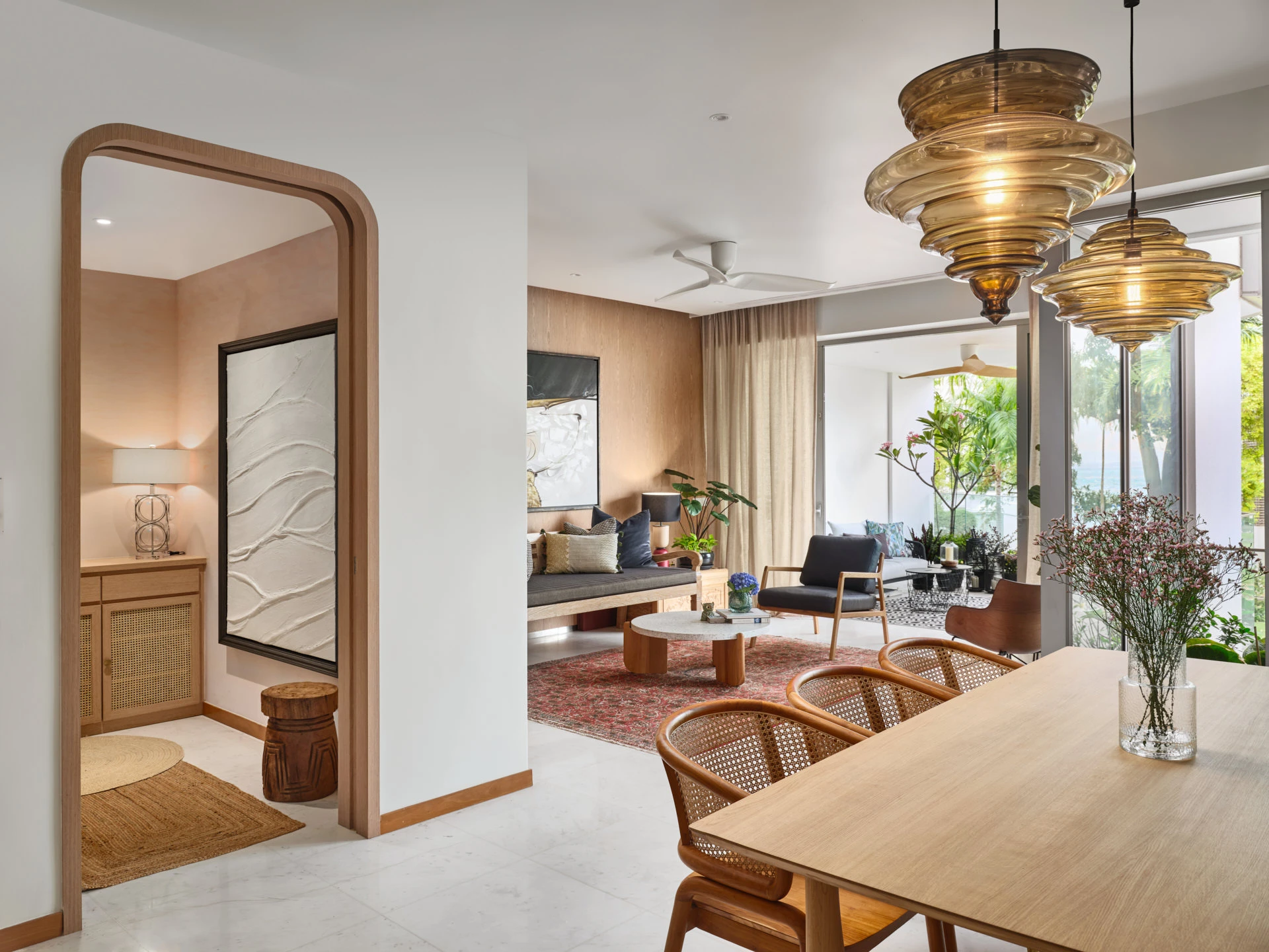 Open-plan with amber pendants, timber arch and tropical garden terrace