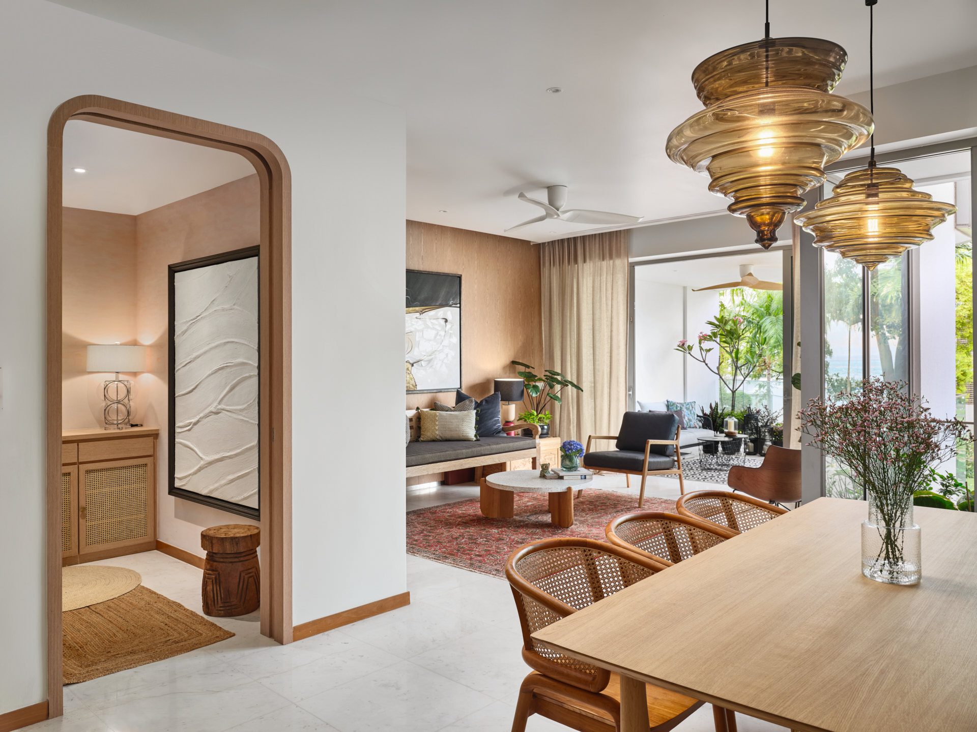 Open-plan with amber pendants, timber arch and tropical garden terrace