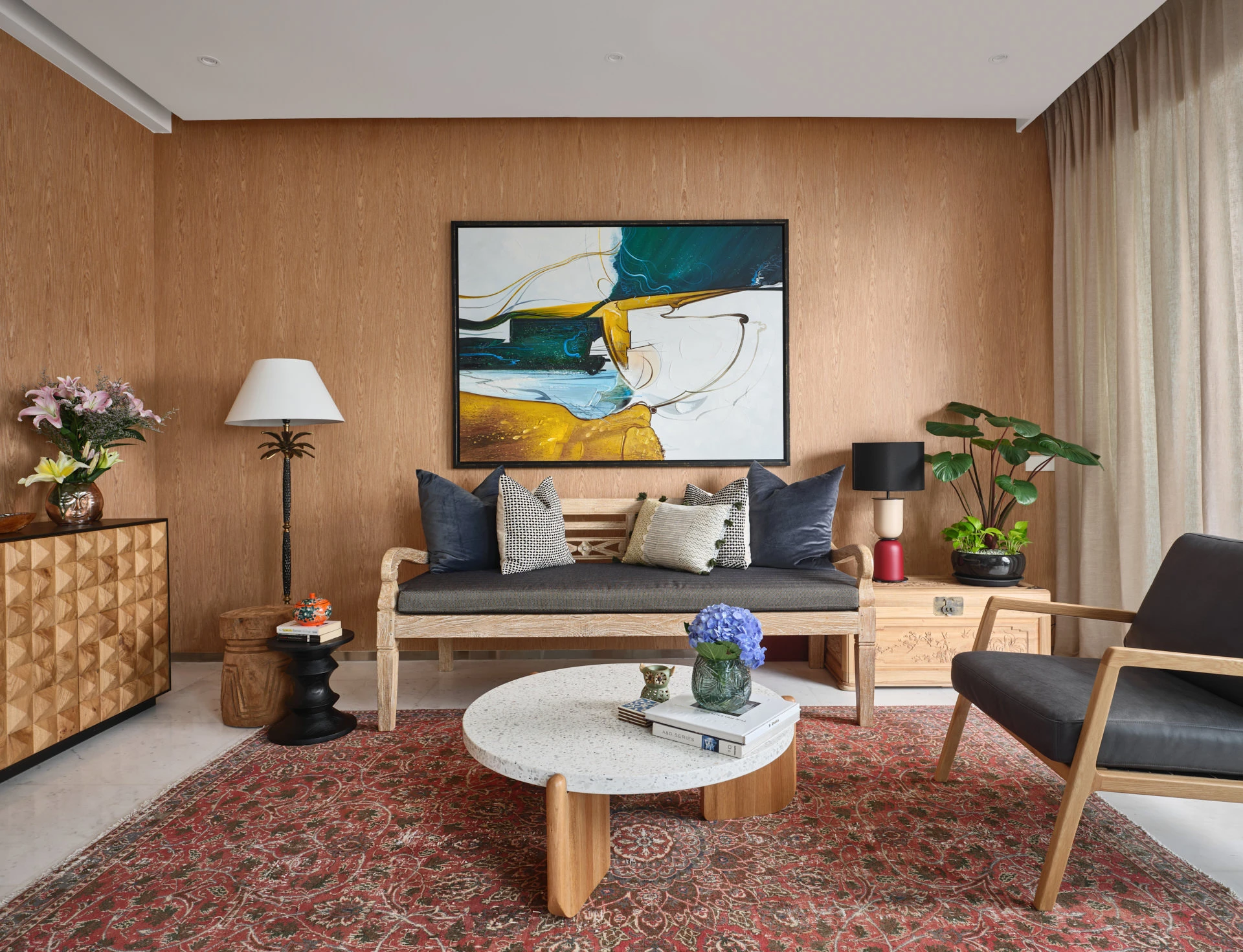 Living room with abstract teal painting, terrazzo table and Persian rug