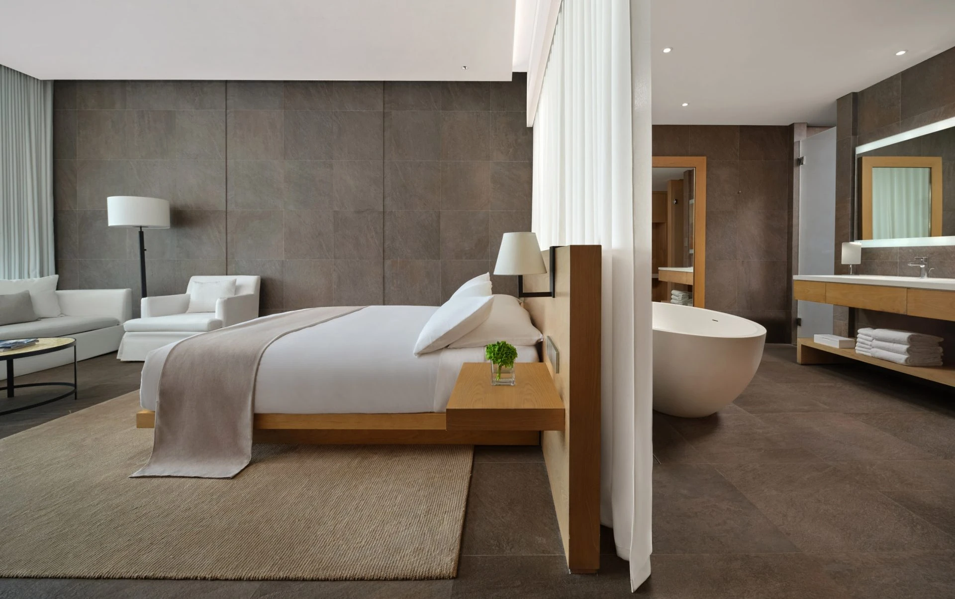 The Sanya EDITION king room with oak bed, freestanding egg tub and sheer divider