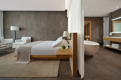 The Sanya Edition hotel standard room with king bed and ocean view at dusk