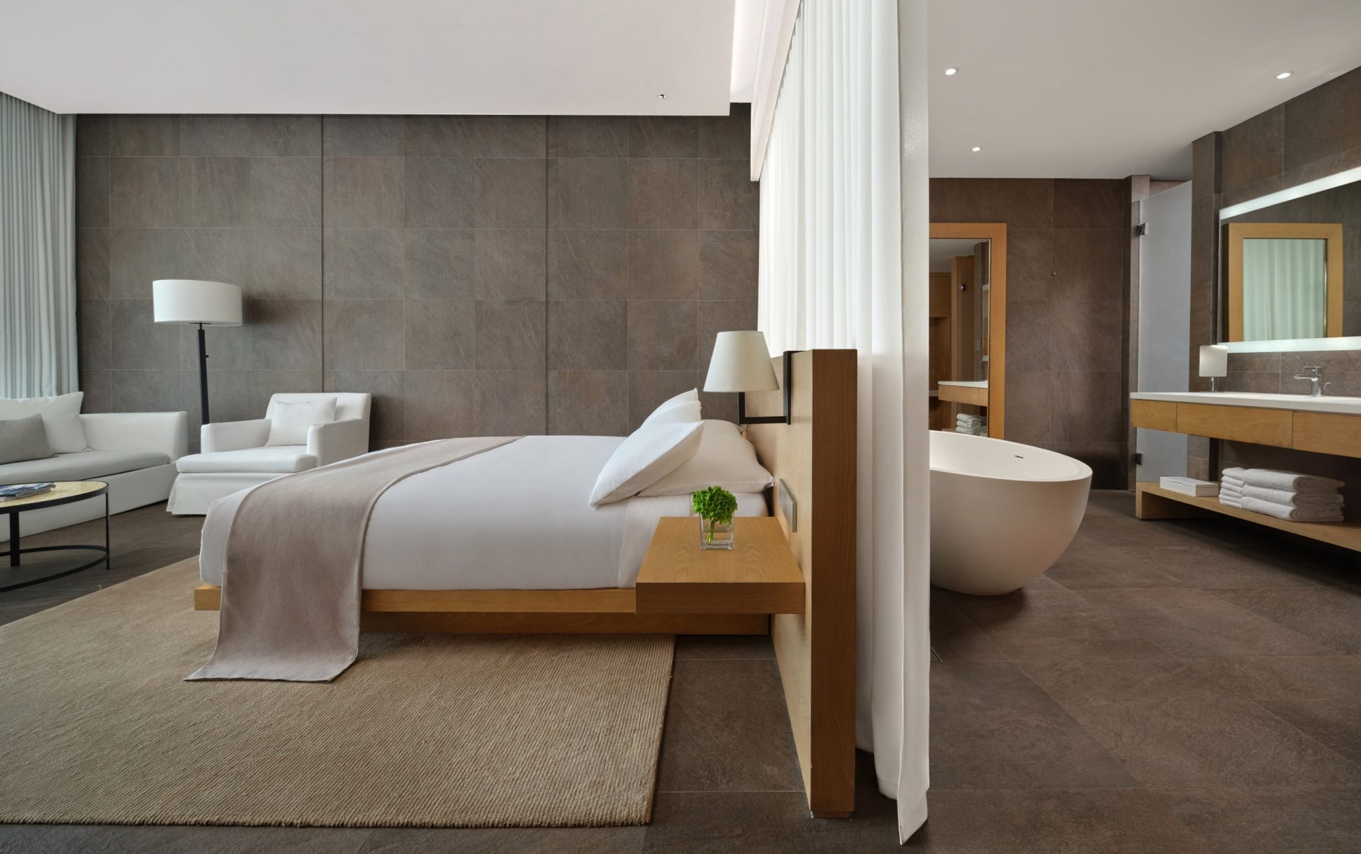 The Sanya EDITION king room with oak bed, freestanding egg tub and sheer divider