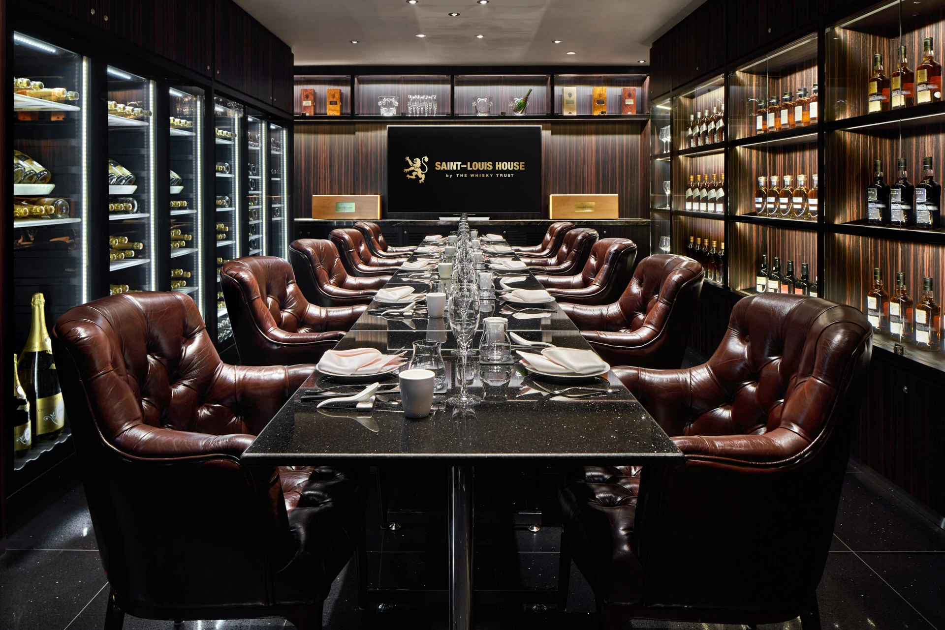 Cristal event room with leather swivel chairs, granite table and whisky display walls