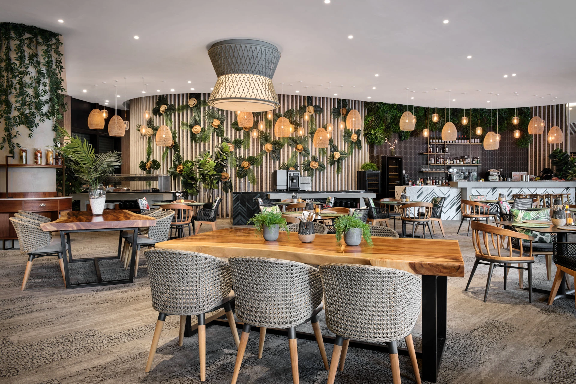 Live-edge communal table with fern centrepieces and slatted wall — Native Kitchen Village Hotel restaurant photography