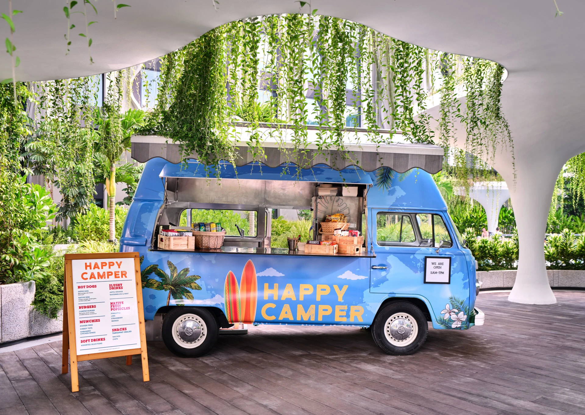 Blue retro VW Happy Camper food truck on tropical deck — Village Hotel Sentosa hospitality photography