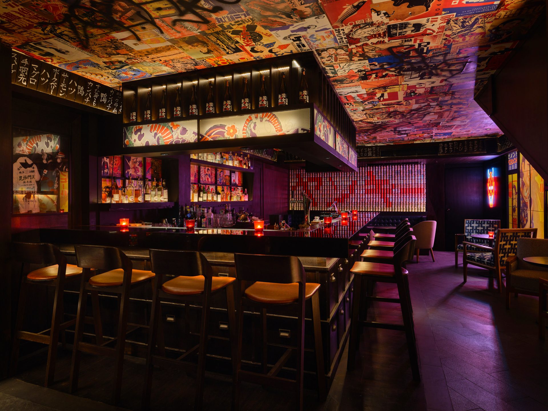 Ground floor bar with patterned seating, neon signage and Japanese pop art walls