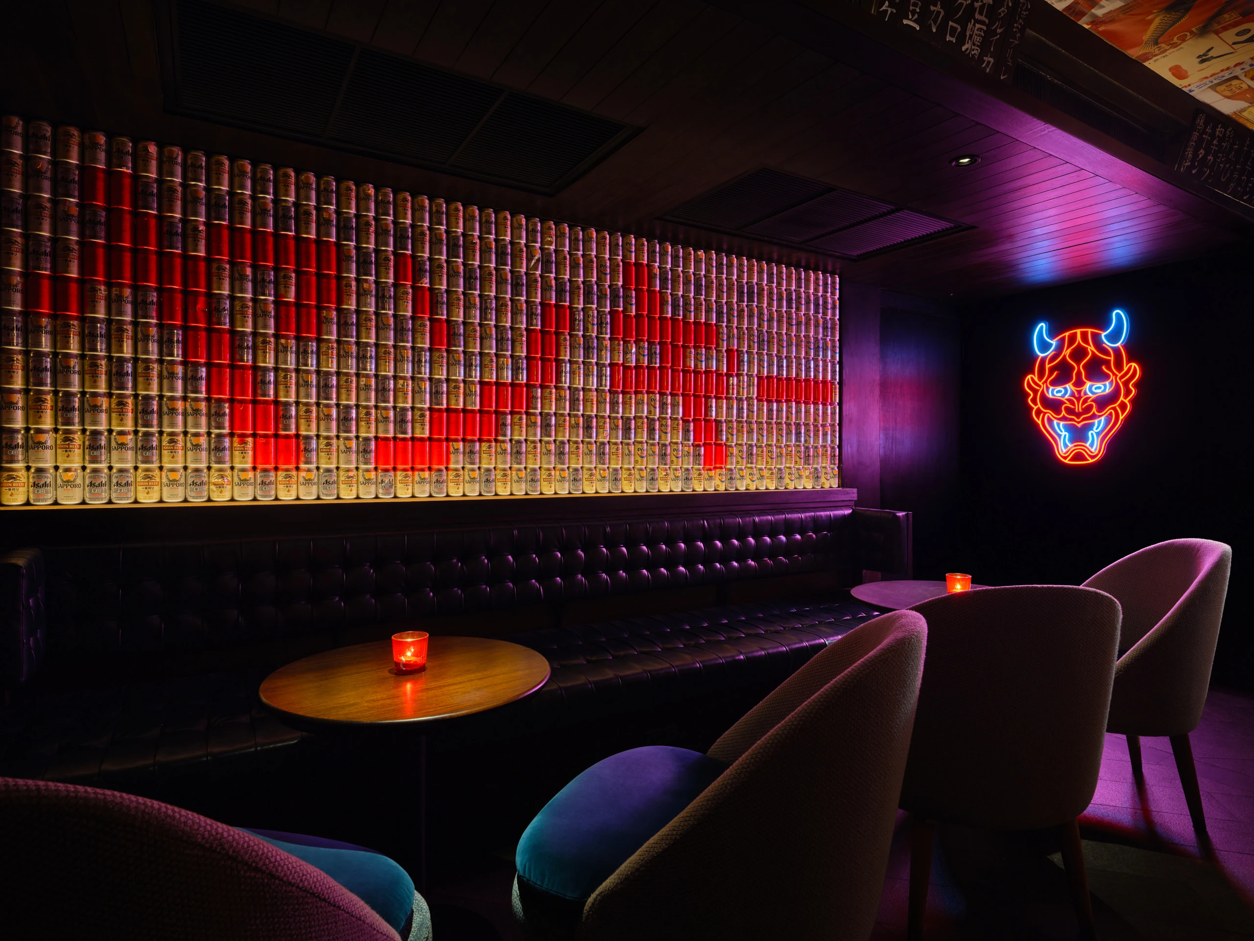 Downstairs lounge seating with pink neon sign and layered wall graphics