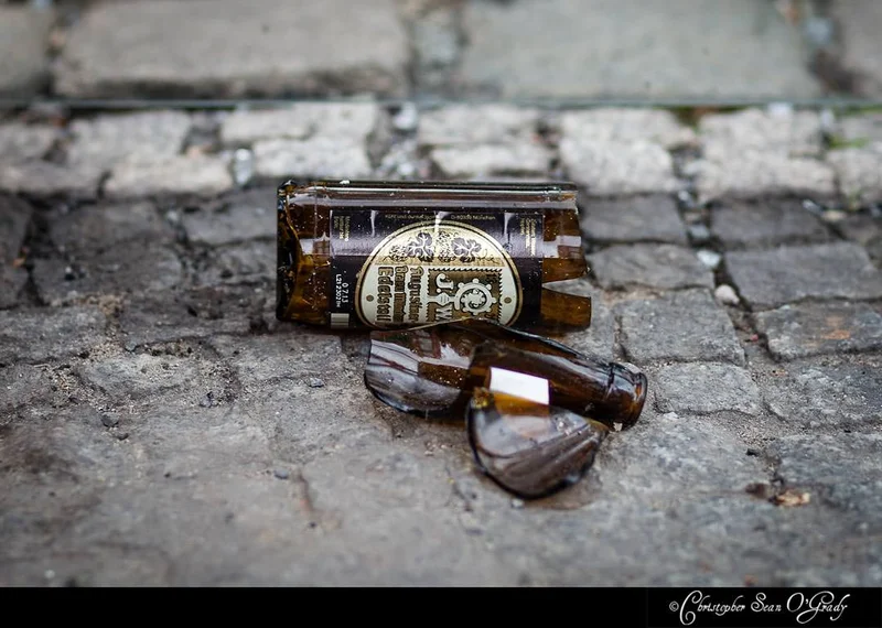 Broken Augustiner Edelstoff beer bottle on wet cobblestones