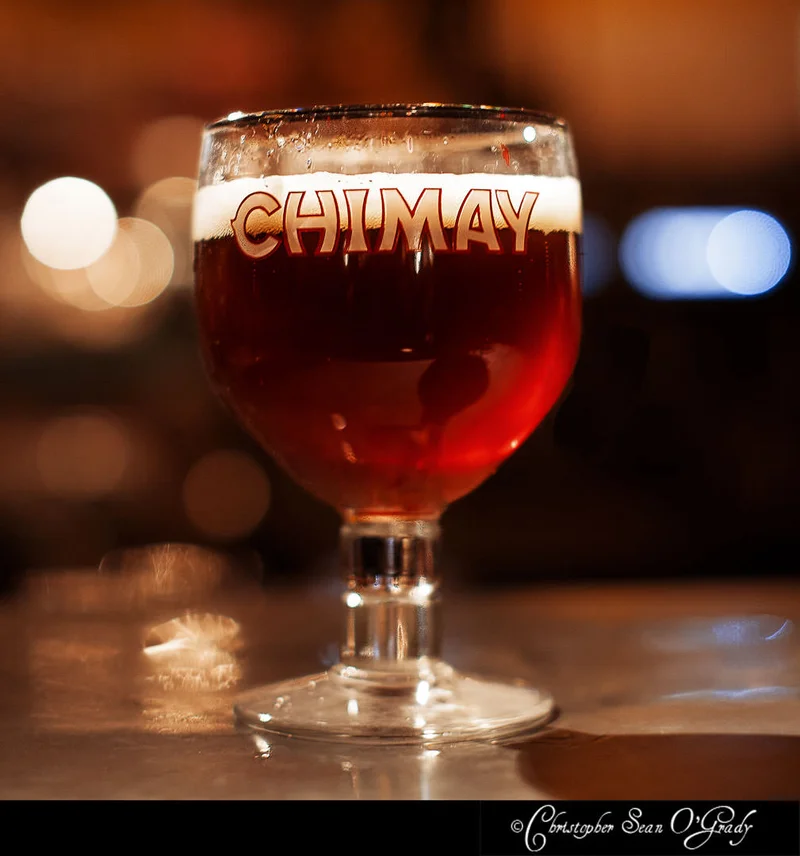 Chimay Belgian ale in a branded goblet at a warm-lit bar