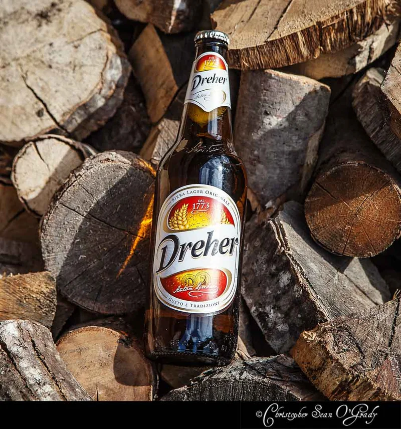 Dreher Birra Lager Originale bottle resting on a stack of firewood logs