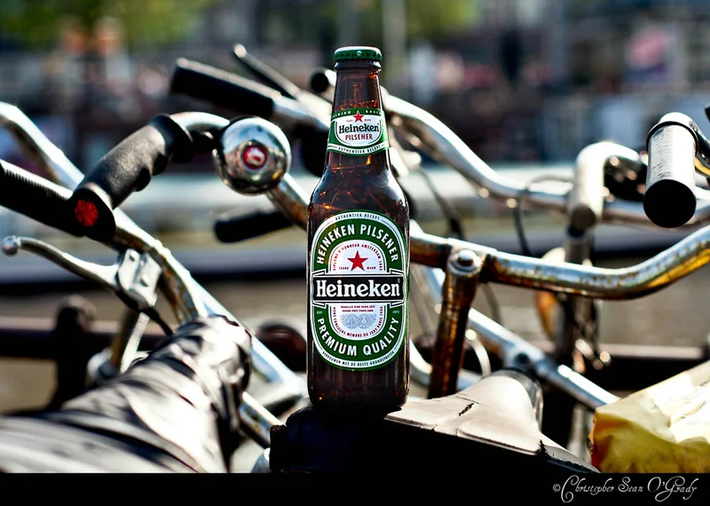 Heineken Pilsener bottle perched among bicycle handlebars in Amsterdam
