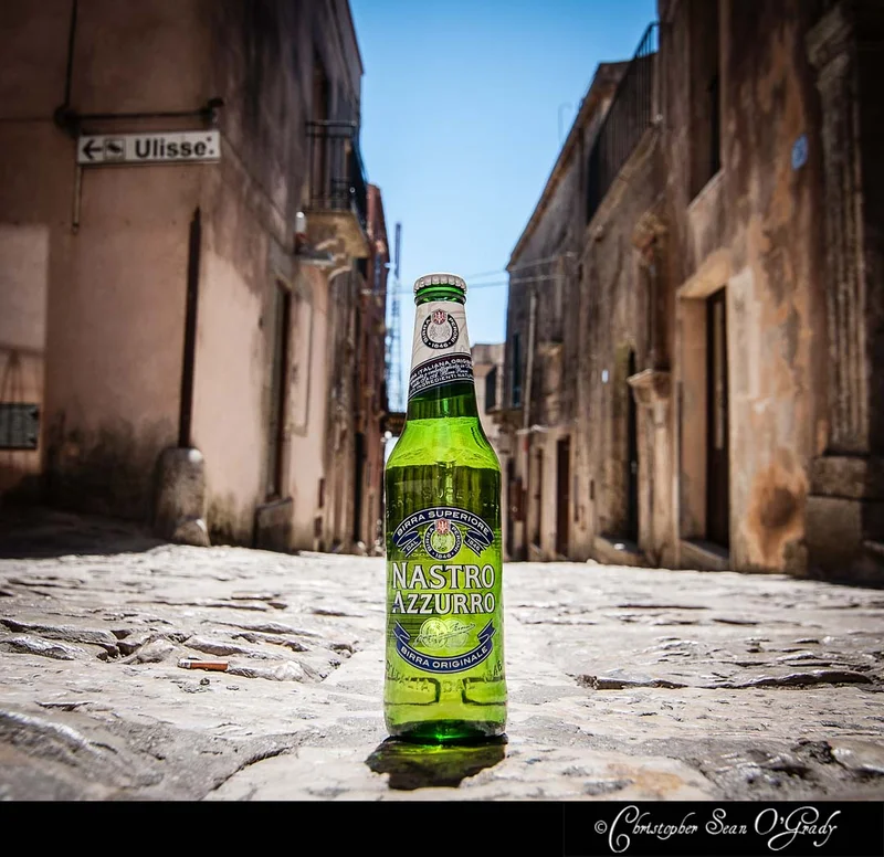 Nastro Azzurro beer bottle on a cobblestone street in an Italian village