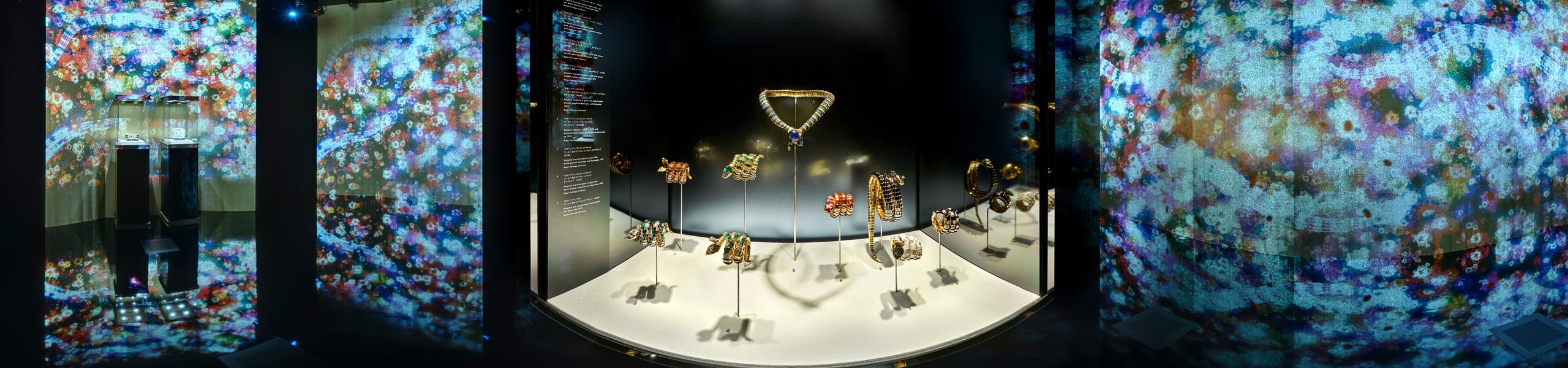 360 panorama of Bulgari Serpentiform jewellery display with gemstone pieces on white platform and projected kaleidoscope walls