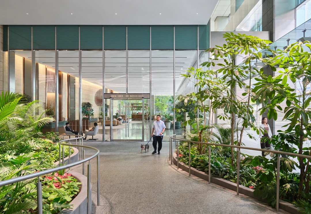 One Raffles Quay South Tower entrance walkway with planters and glass facade