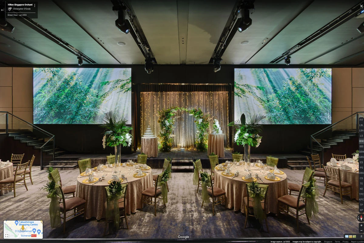 Wedding ballroom with floral arch, banquet tables, and LED screens at Hilton Singapore Orchard hotel virtual tour
