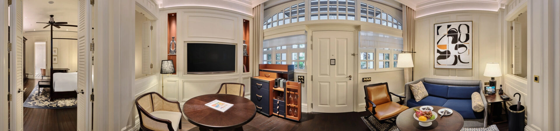 360 panorama of Raffles Hotel courtyard suite parlour with colonial shutters, blue sofa, minibar and cane chairs