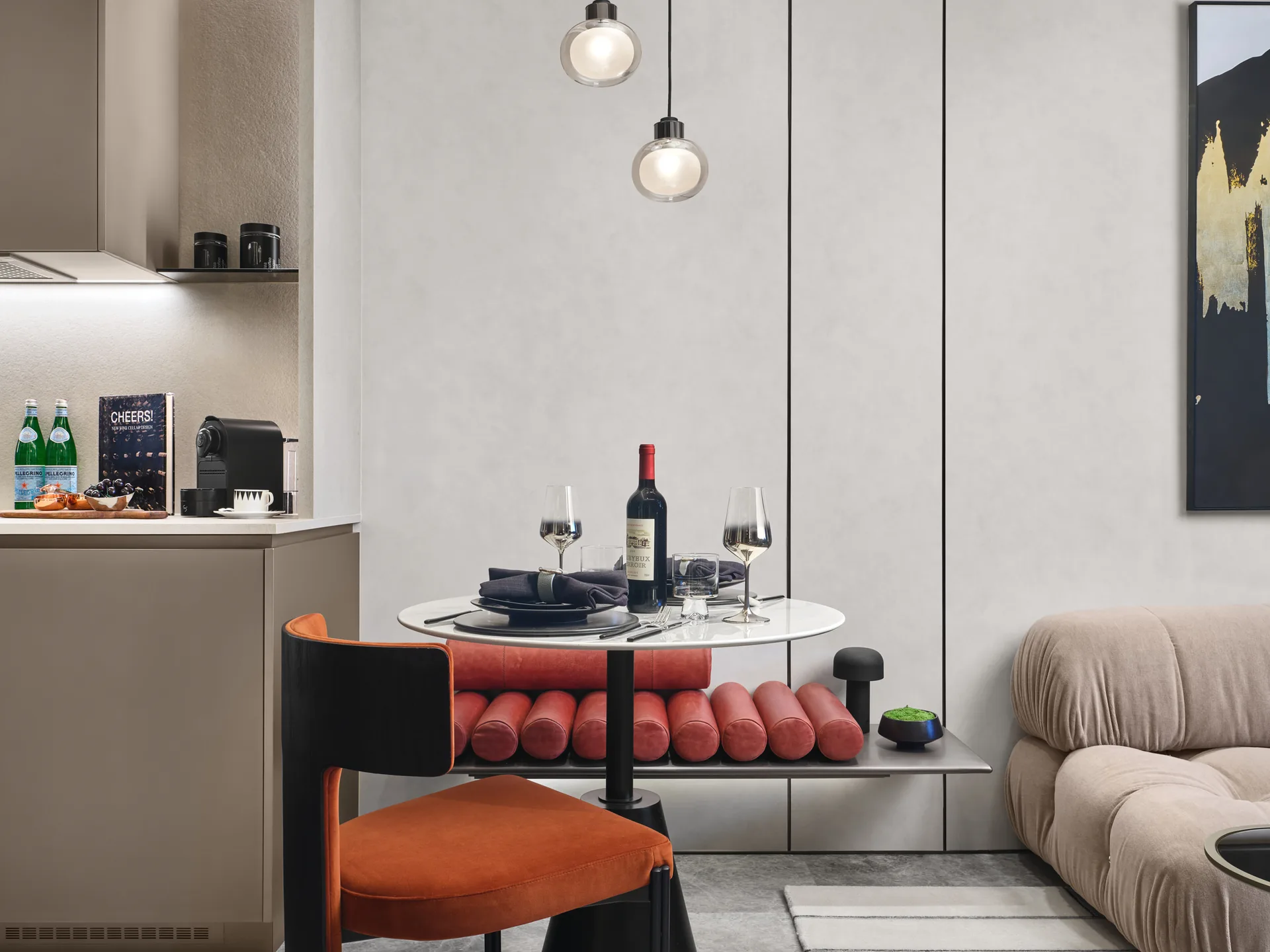 W Residences 1-bedroom showflat dining nook and kitchen with round table, red bench and compact cabinetry, detail view