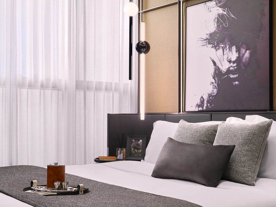 W Residences 1-bedroom showflat bedroom with sheer curtains, layered neutral bedding and black pendant light, detail view