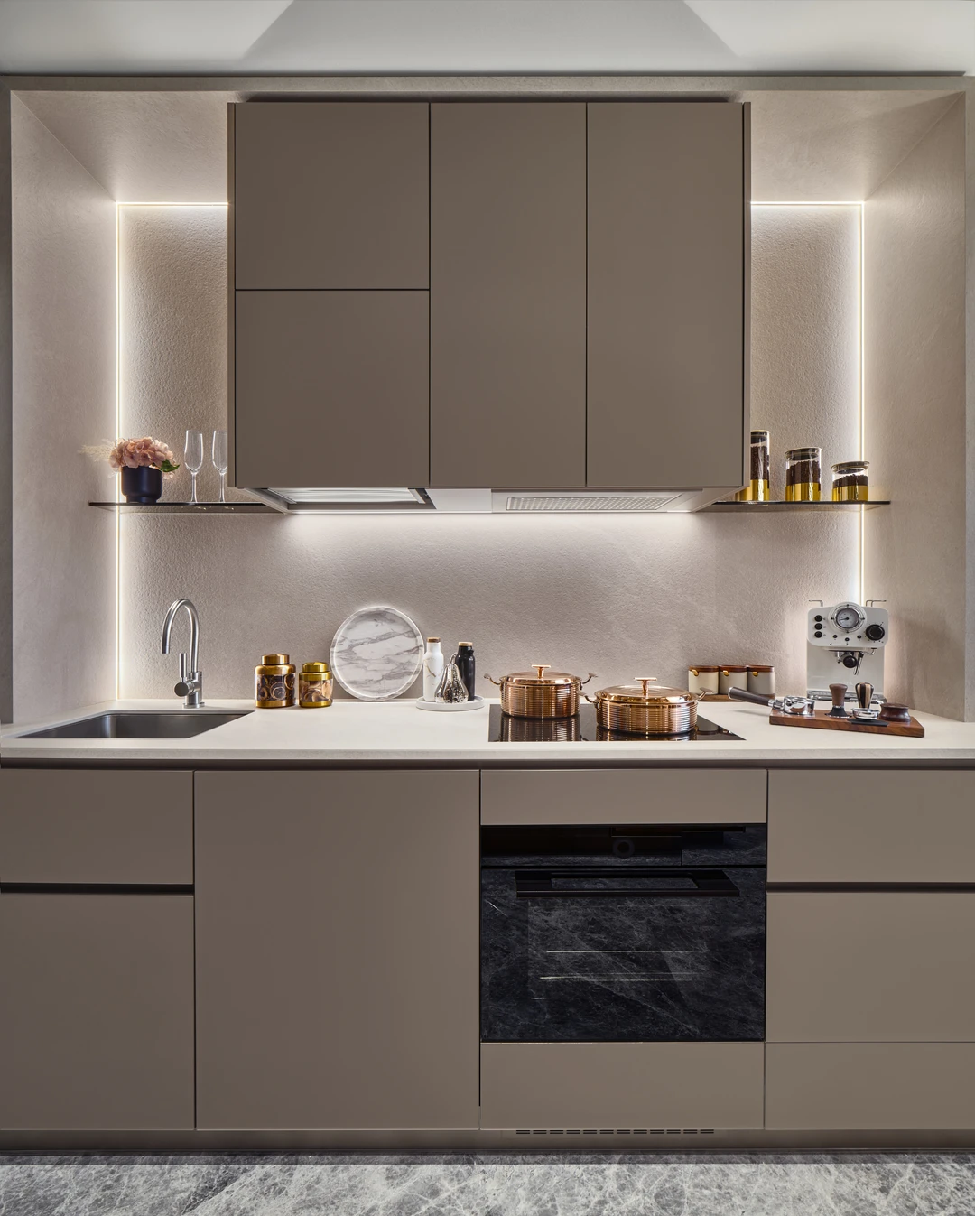 W Residences 2-bedroom showflat kitchen with pale cabinetry, marble-look backsplash and copper cookware, wide view