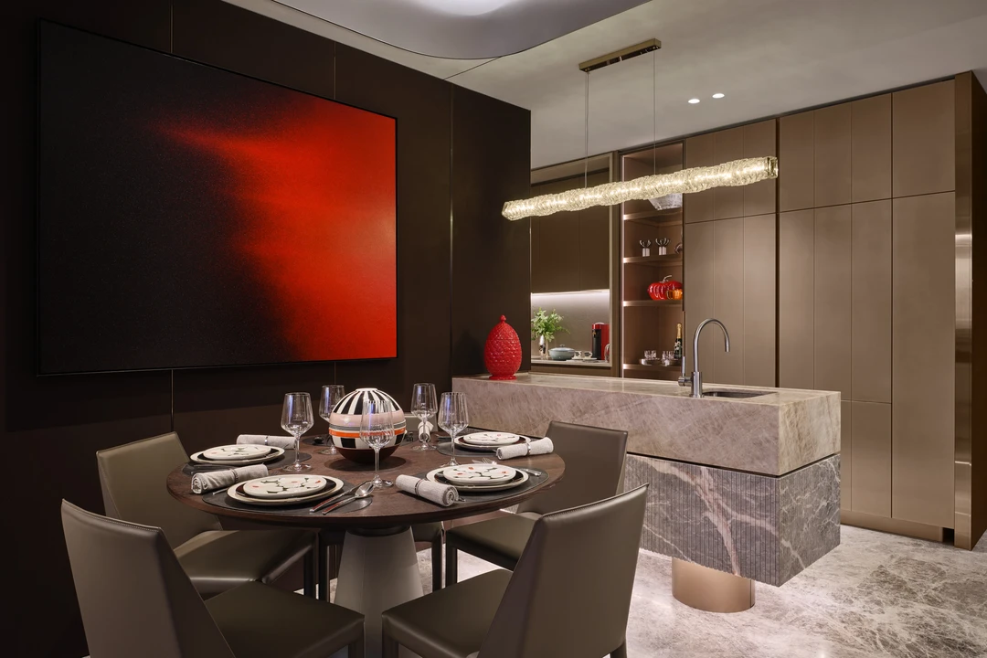 W Residences 3-bedroom showflat dining area with dark table setting, marble island and mirrored kitchen cabinetry