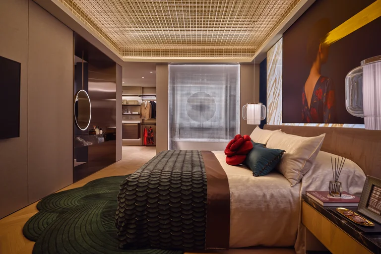 W Residences 5-bedroom showflat master bedroom with warm lighting, dark green bedding and art wall