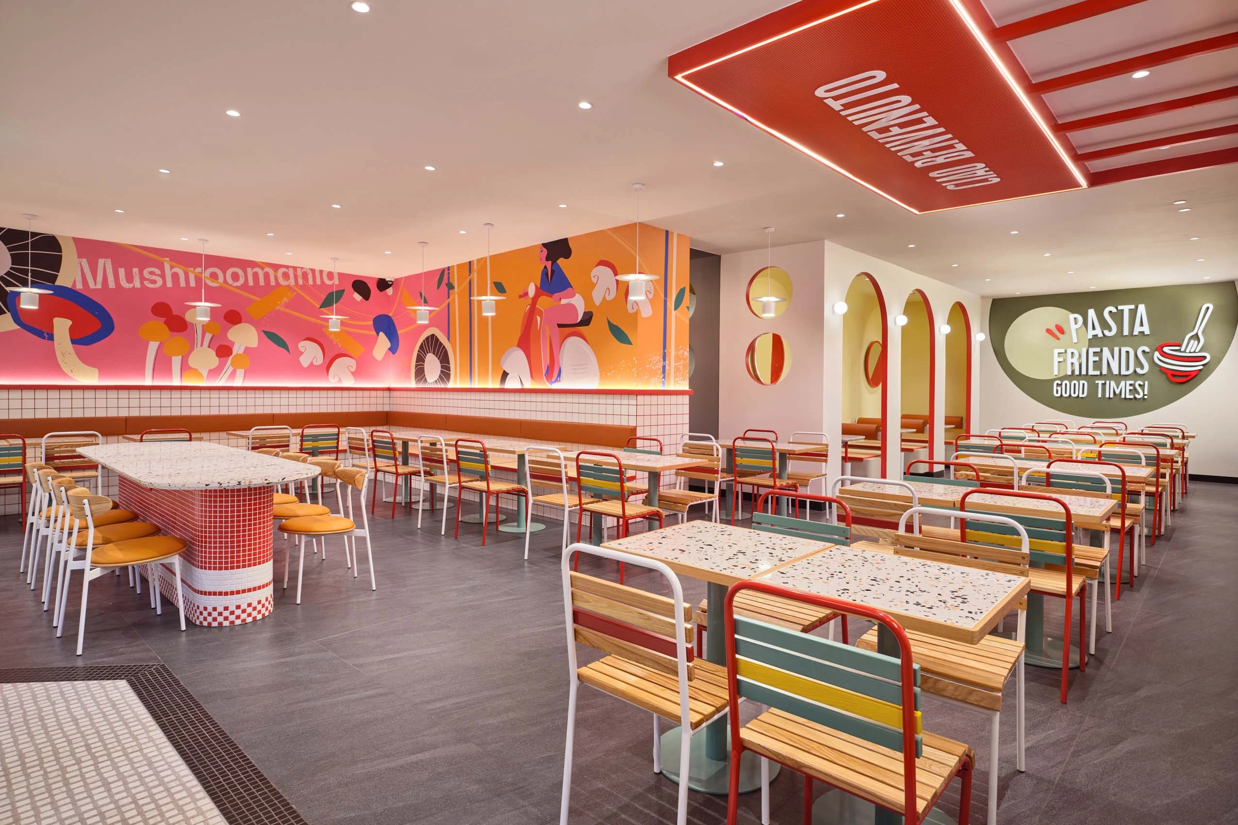 PastaMania Lot One wide view of dining hall showing mural wall, red ceiling feature, and Pasta Friends Good Times signage