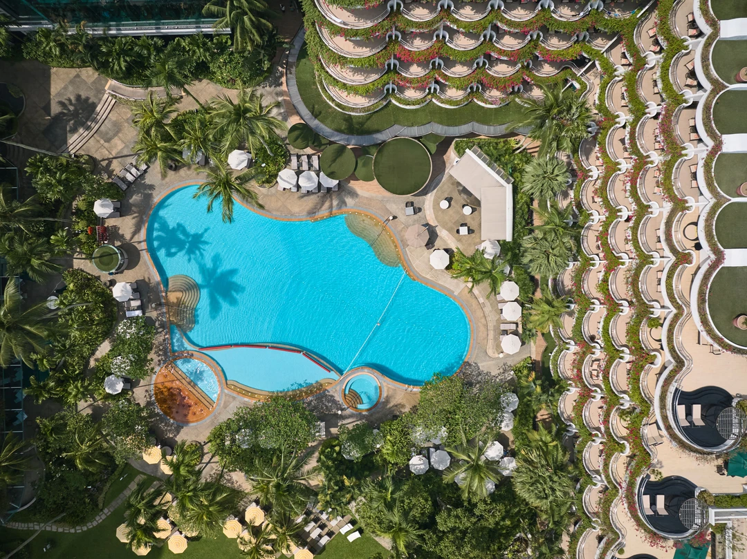 Bird’s eye aerial view of Shangri-La Hotel Singapore freeform pool and tropical landscaping