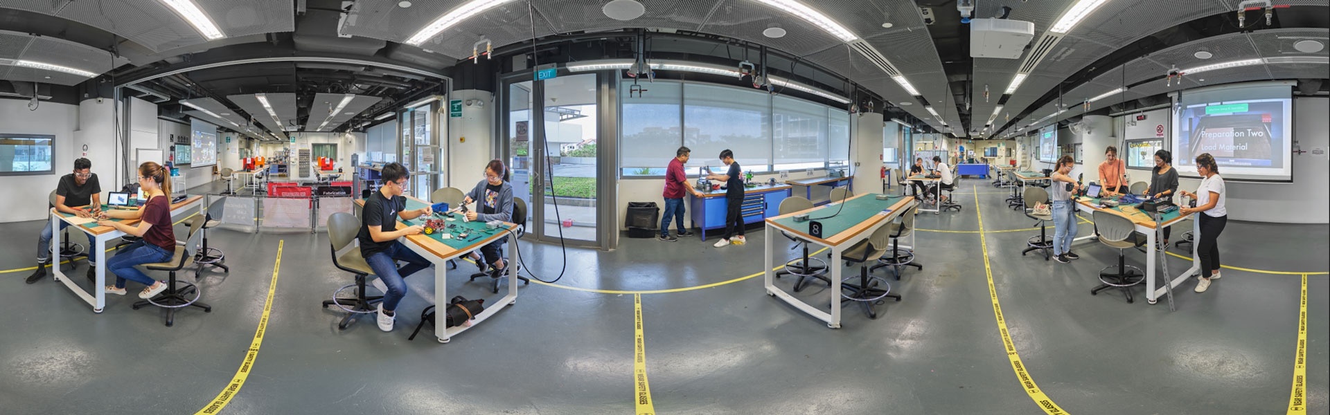 360 panorama of SUTD fabrication lab with students at workbenches, soldering equipment and prototyping tools