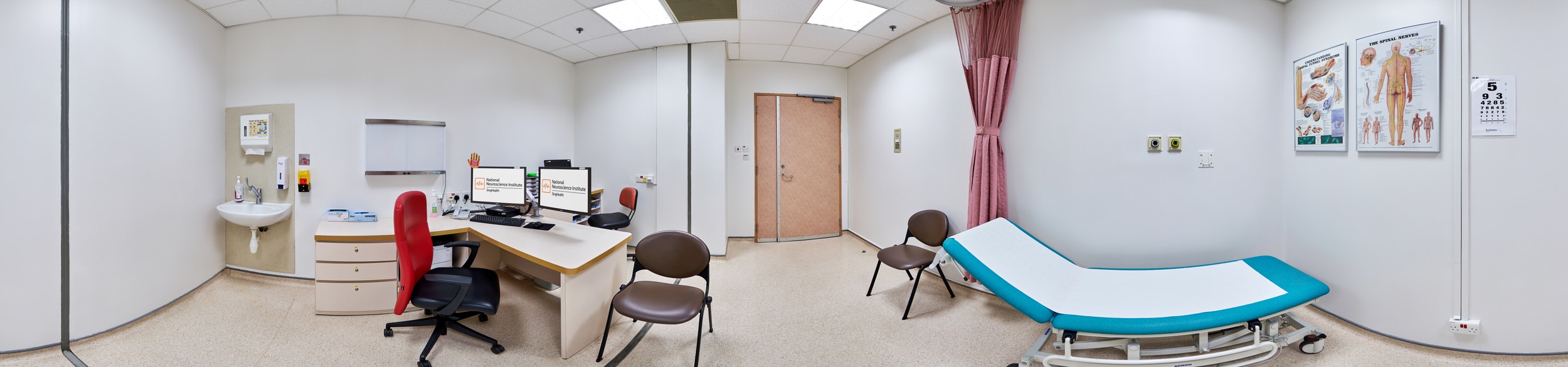 360 panorama of NNI consultation room with dual monitors, examination bed, eye chart and anatomical posters