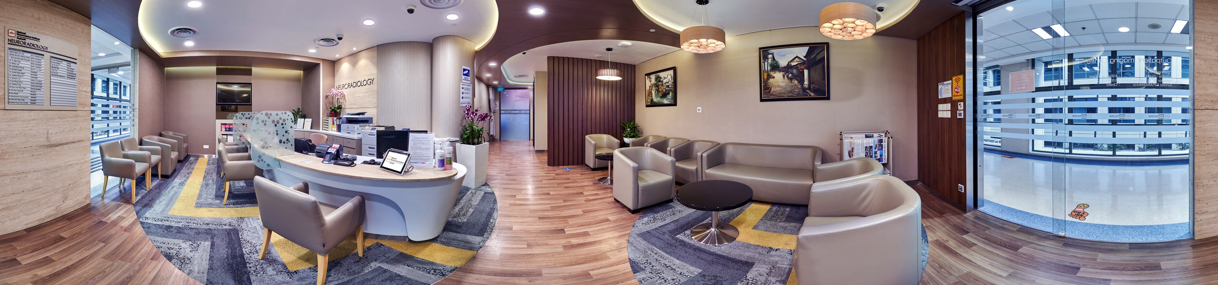 360 panorama of NNI neuroradiology clinic reception with curved desk, lounge seating and warm timber accents