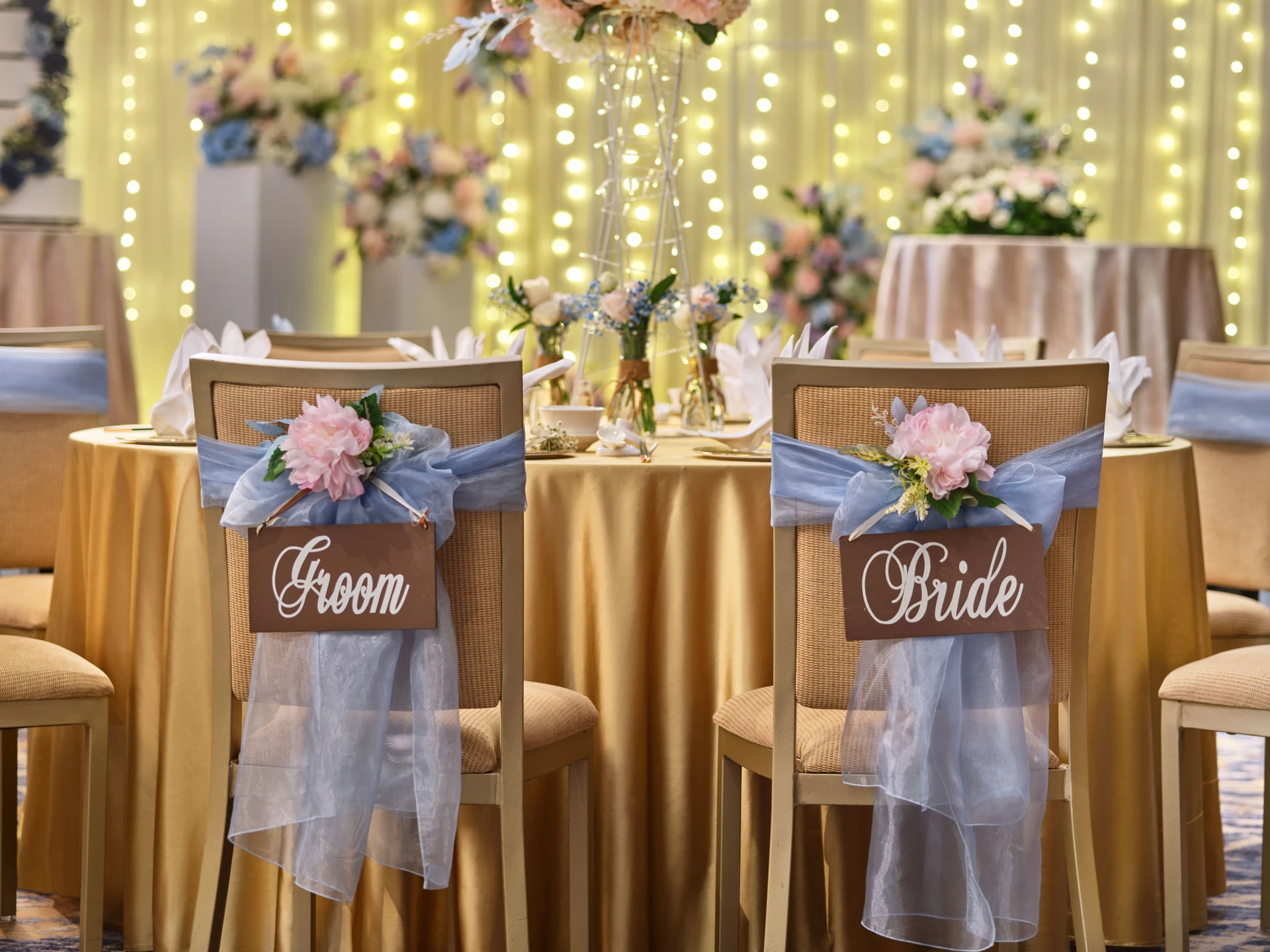 Bride and groom chairs with peach sashes in champagne gold and dusty blue palette - voco Orchard Singapore wedding photography