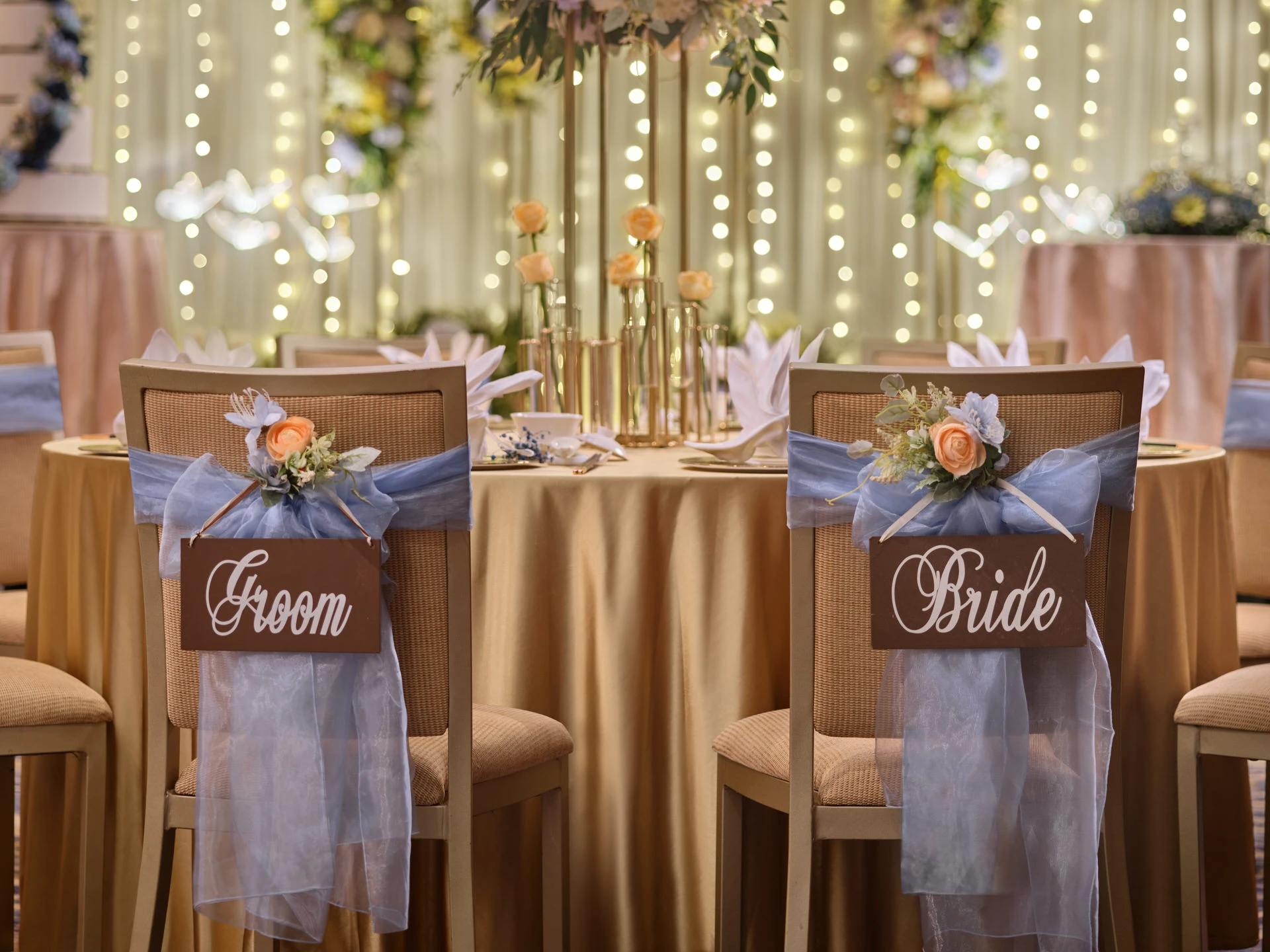 Sweetheart chairs with blue sashes and wooden signs at banquet table - voco Orchard Singapore wedding photography