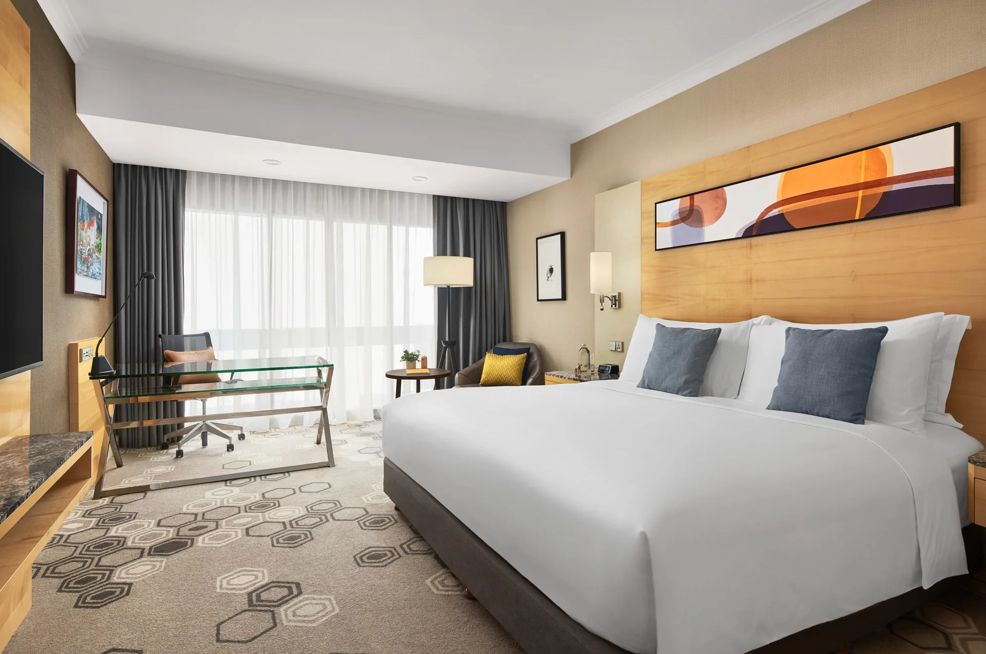 Wide room view with blue pillows, desk nook and seating area