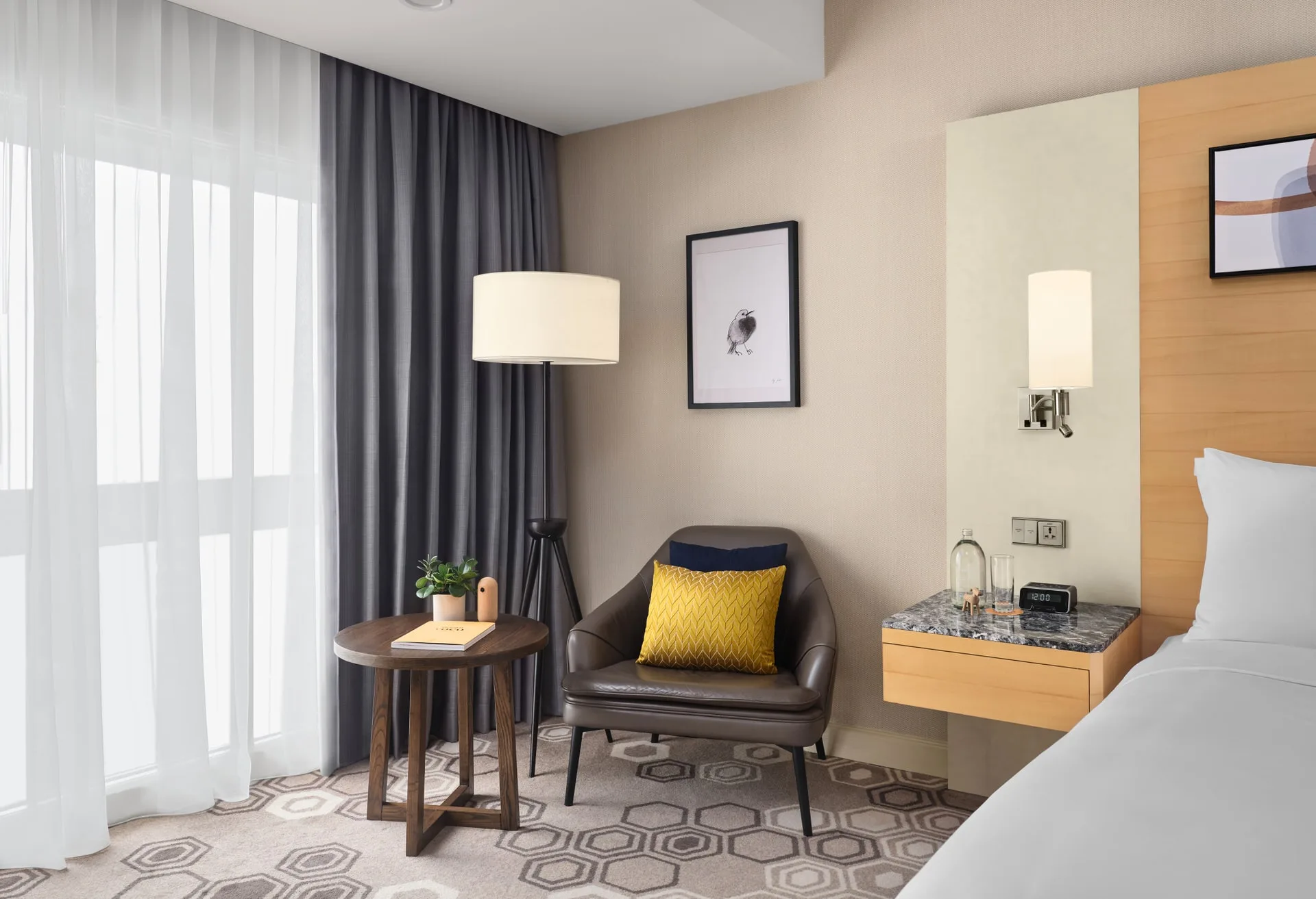Reading nook with leather armchair, tripod lamp and mustard cushion
