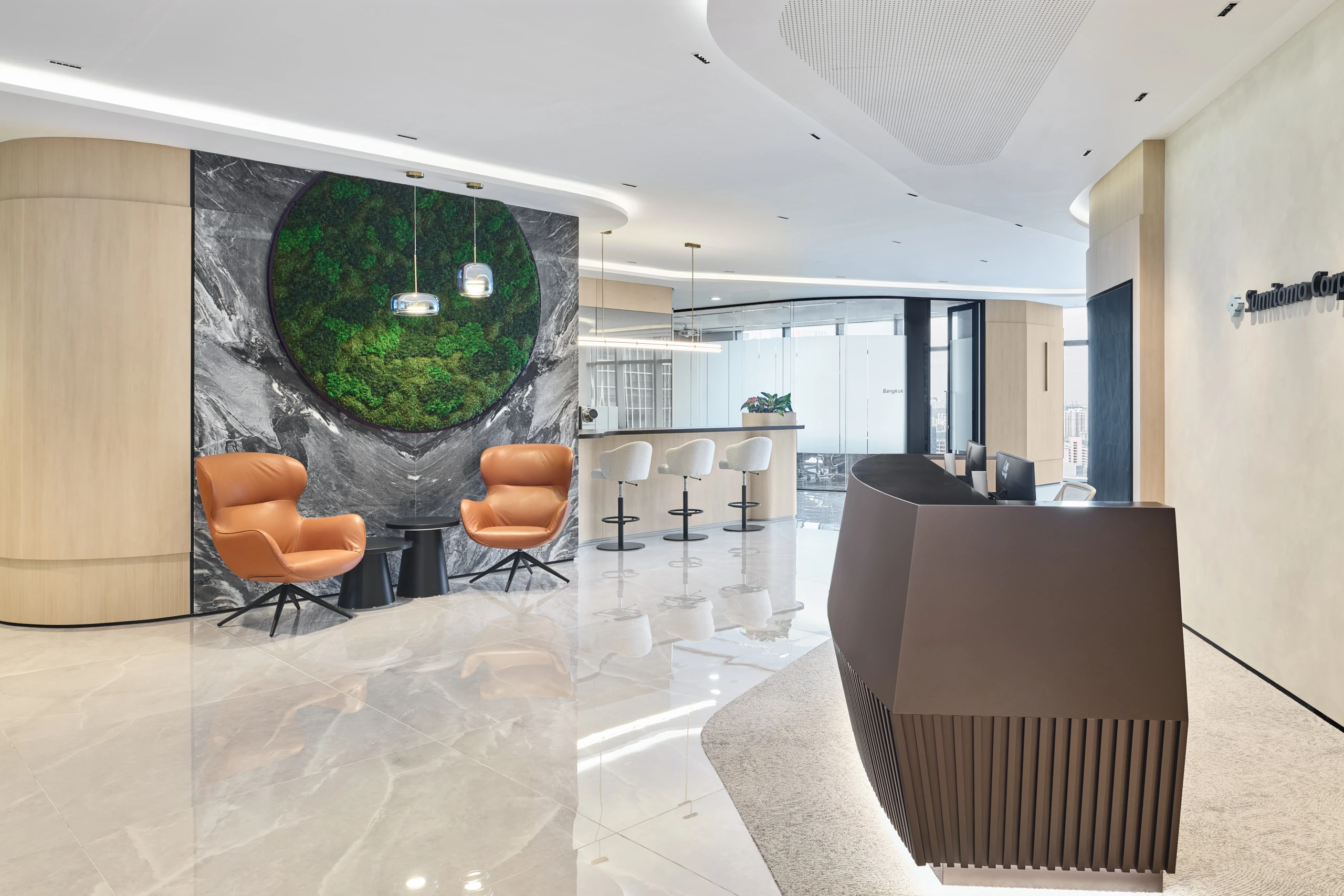 Corporate reception with circular moss art, marble wall and leather chairs