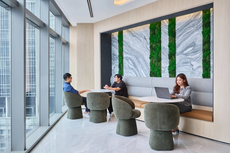 Breakout lounge with moss feature wall, barrel chairs and natural light
