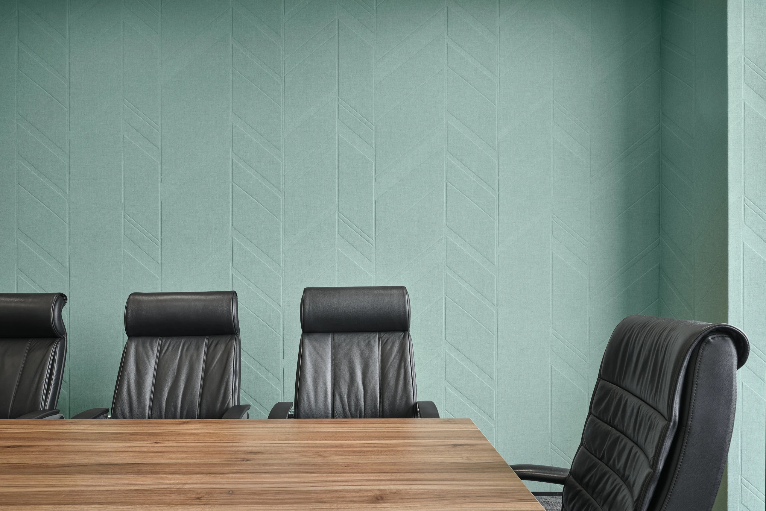 Executive boardroom with walnut table and mint chevron acoustic panels