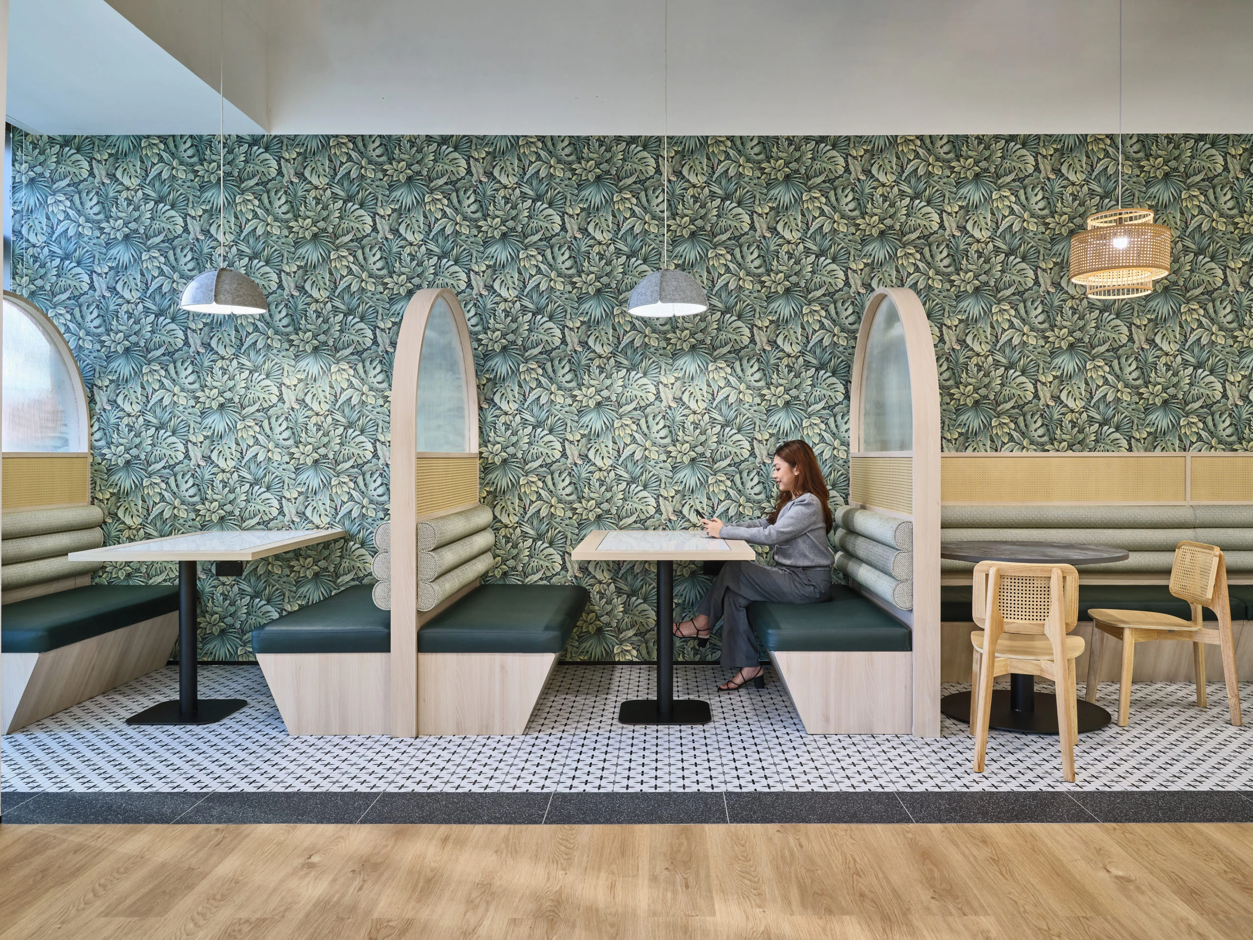 Tropical monstera booth seating with arched timber dividers and mosaic floor